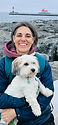 Owner of Kinder K9 holding white dog.