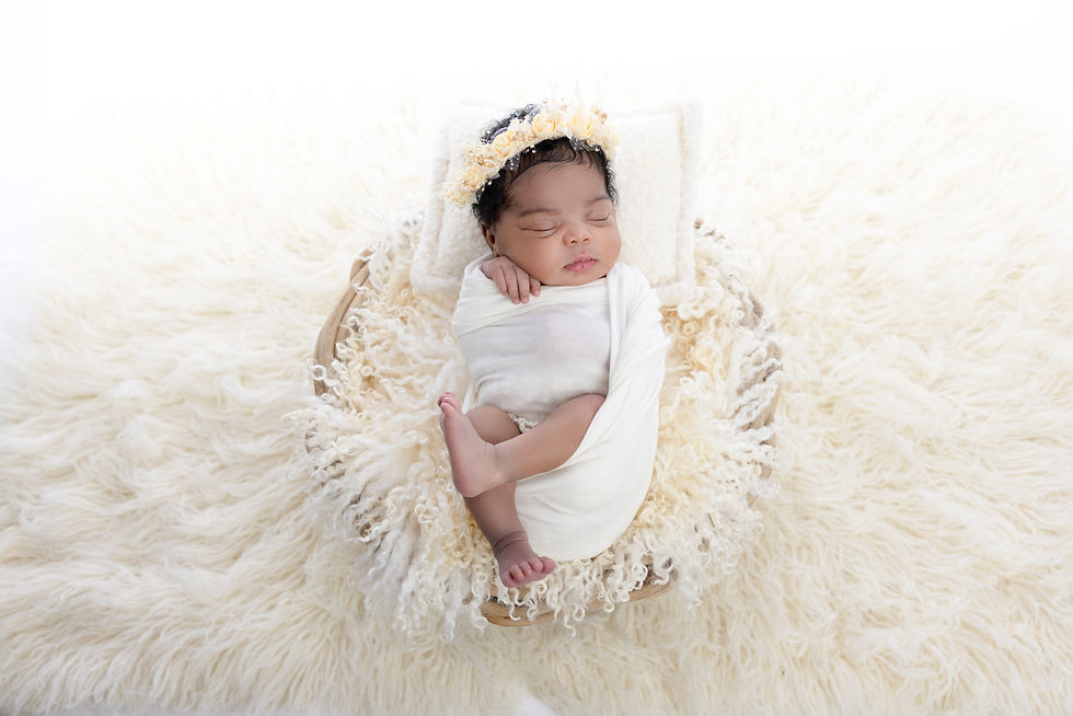 Newborn wrapped in white on a fluffy fur blanket, pictured in San Diego newborn photography studio