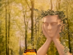 Aromatherapy candle labeled CLEAR THINKING on a white table, with a serene mannequin head wrapped in greenery against a forest backdrop at Laura Starky's Beverley-based somatic therapy space.