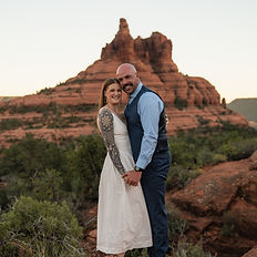 A couple poses for a photo in front of Bell Rock