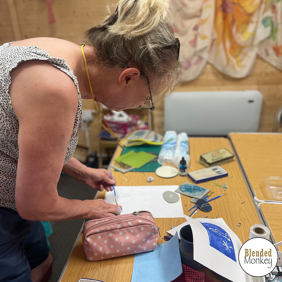 Student cutting out her design into the lino