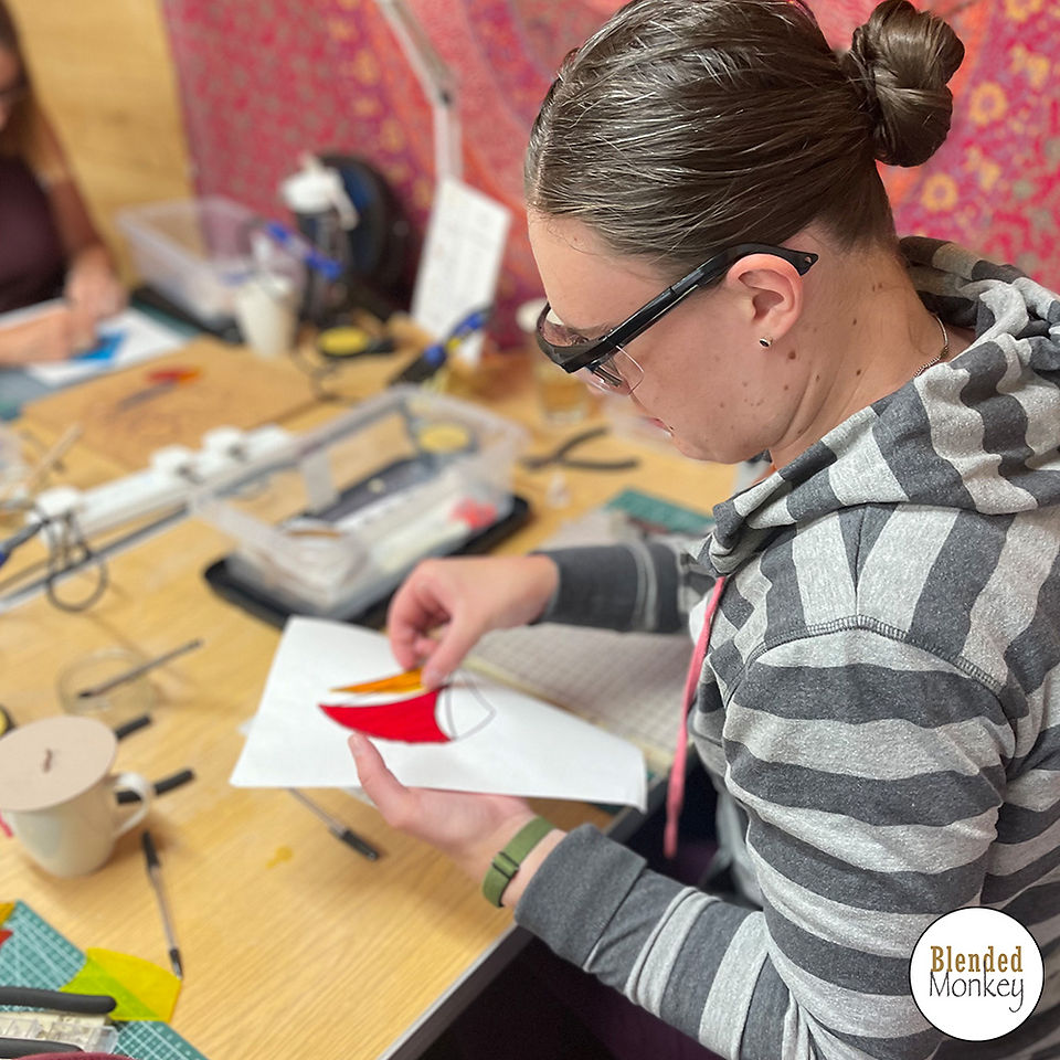 Student placing her glass shapes for her copper foil ornament here in the Blended Monkey Studios