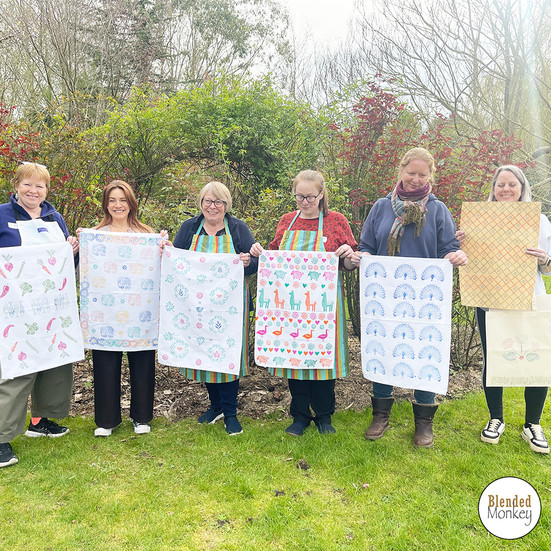 Happy group of students showing off their block-printed tea towels