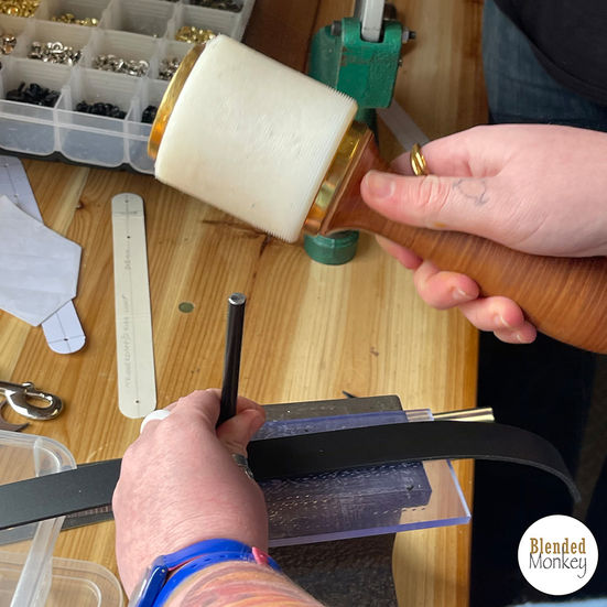 Student punching a shape into the belt loop