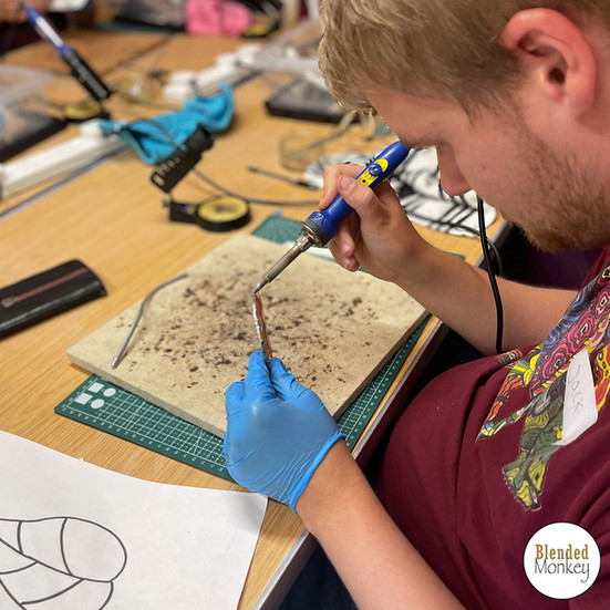 Student soldering his ornament here in the Blended Monkey Studios