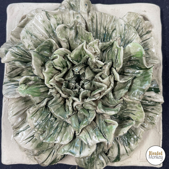 Clay blossom tile with green petals created during a workshop at Blended Monkey