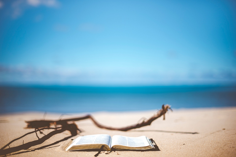 One of the best books to read this summer lying open on sand opposite the blue sea.