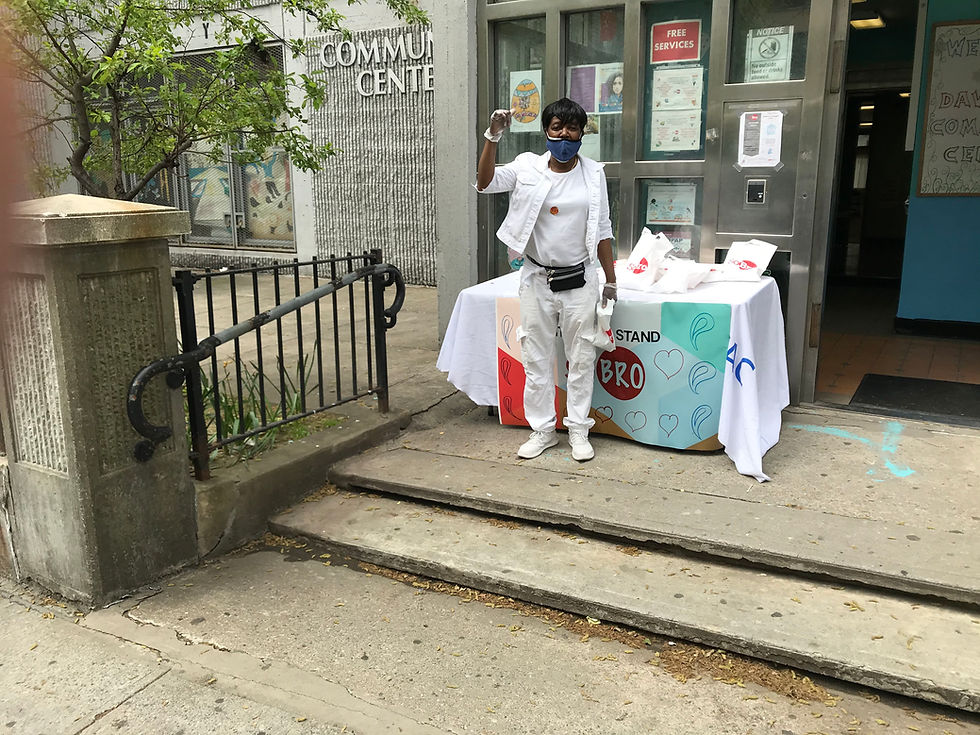 Woman in front of Bronx community center handing out care packages