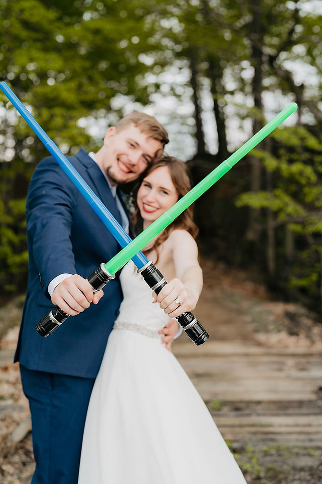 bride and groom crossing light sabers
