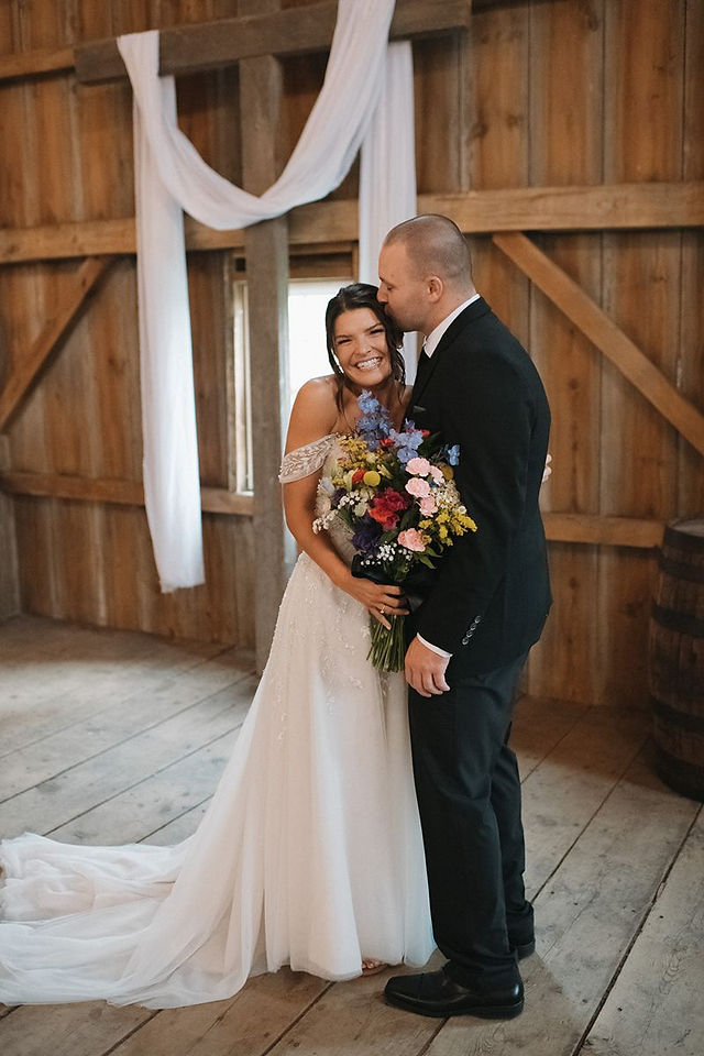 wildflower bride and groom in barn wedding ceremony