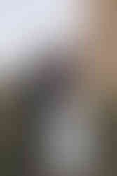 bride and groom kissing in front of arlington acres, a white barn wedding venue in tiffin ohio