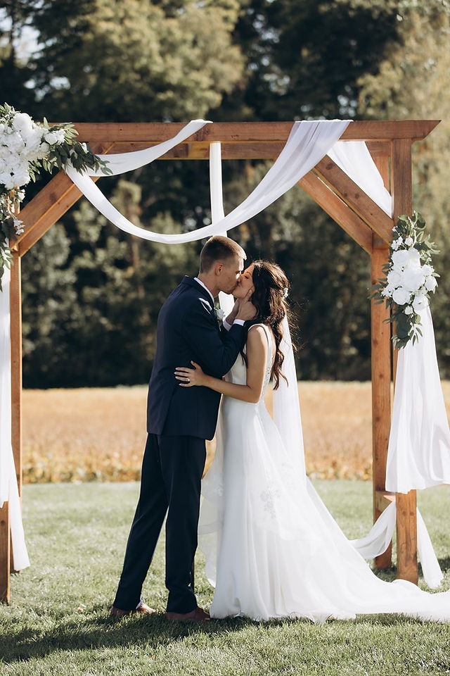 bride and groom kissing during outdoor wedding ceremony