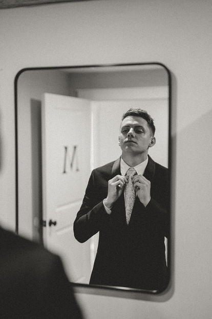 Groom getting ready in the mirror