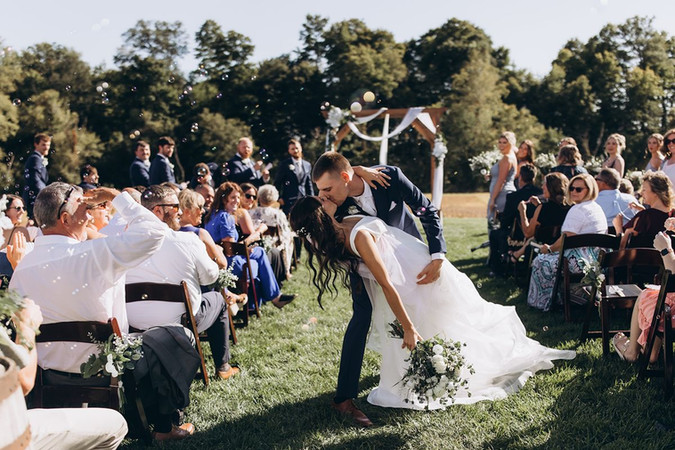 bride and groom kissing at the end of the aisle
