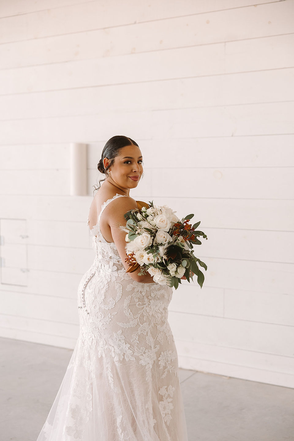 Bride with white and rust bouquet