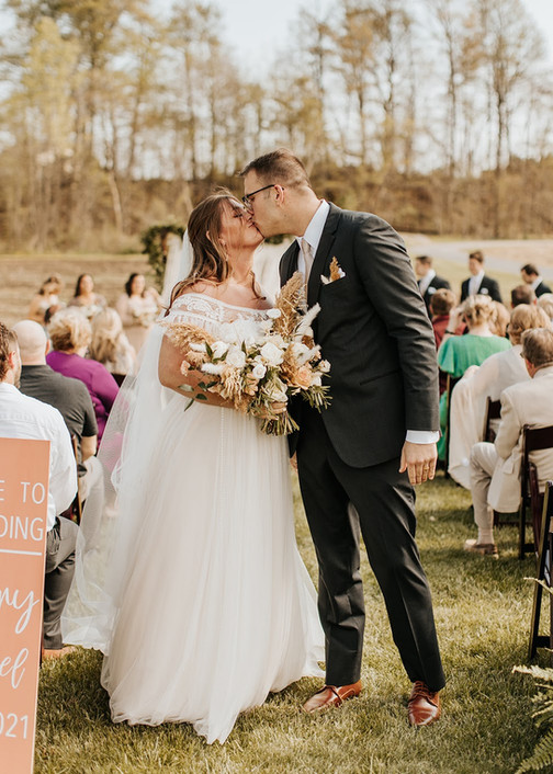 couple kissing after spring outdoor wedding ceremony