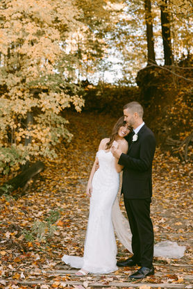 Bride and groom on a bridge surrounded by fall foliage