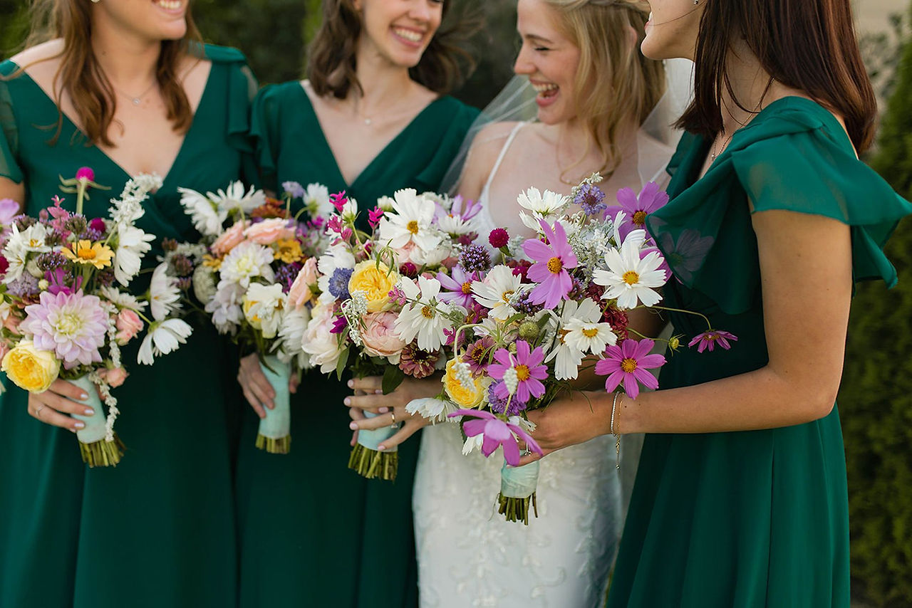 Dark green bridesmaids and wildflower bridal bouquets