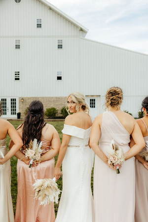 bride in front of white barn wedding venue