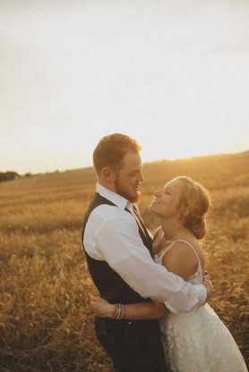 Bride and groom at sunset in a wheat field