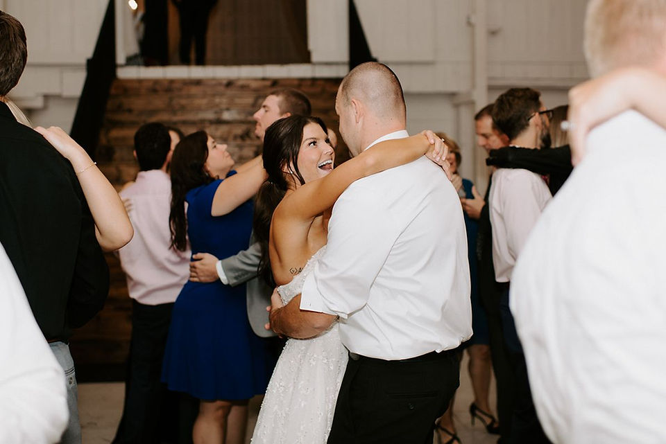 bride and groom dancing in white barn wedding reception