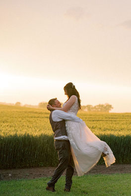 groom spinning bride at sunset