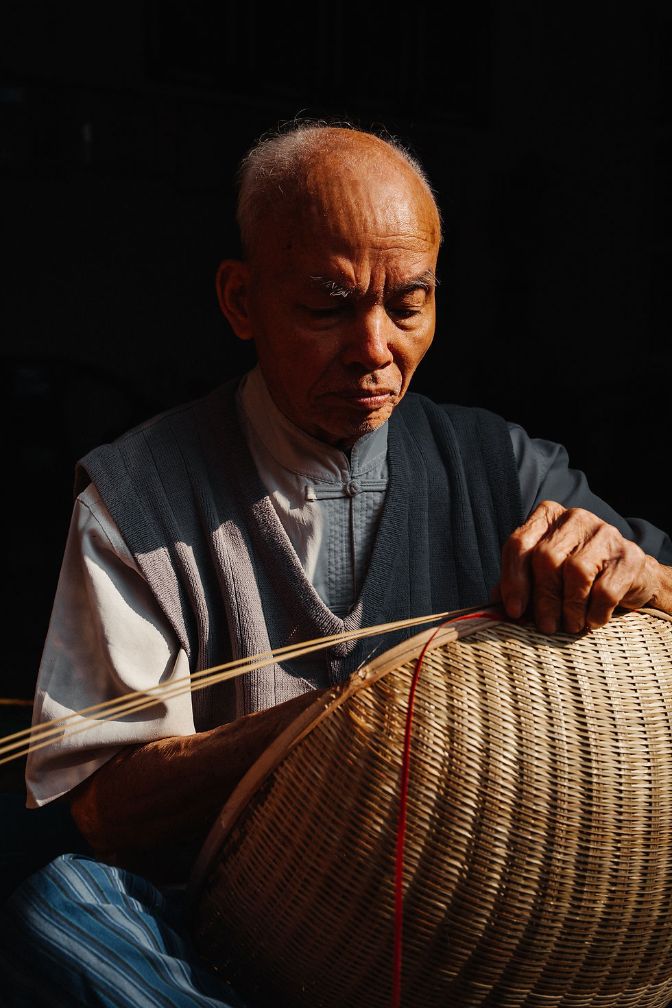 Portrait of a Man crafting a bamboo basket in Vietnam