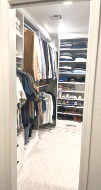 A beautiful and functional white closet transformation designed for both his and her needs. It features separate hanging sections, individual drawers, and adjustable shelves for shoes and folded clothes.