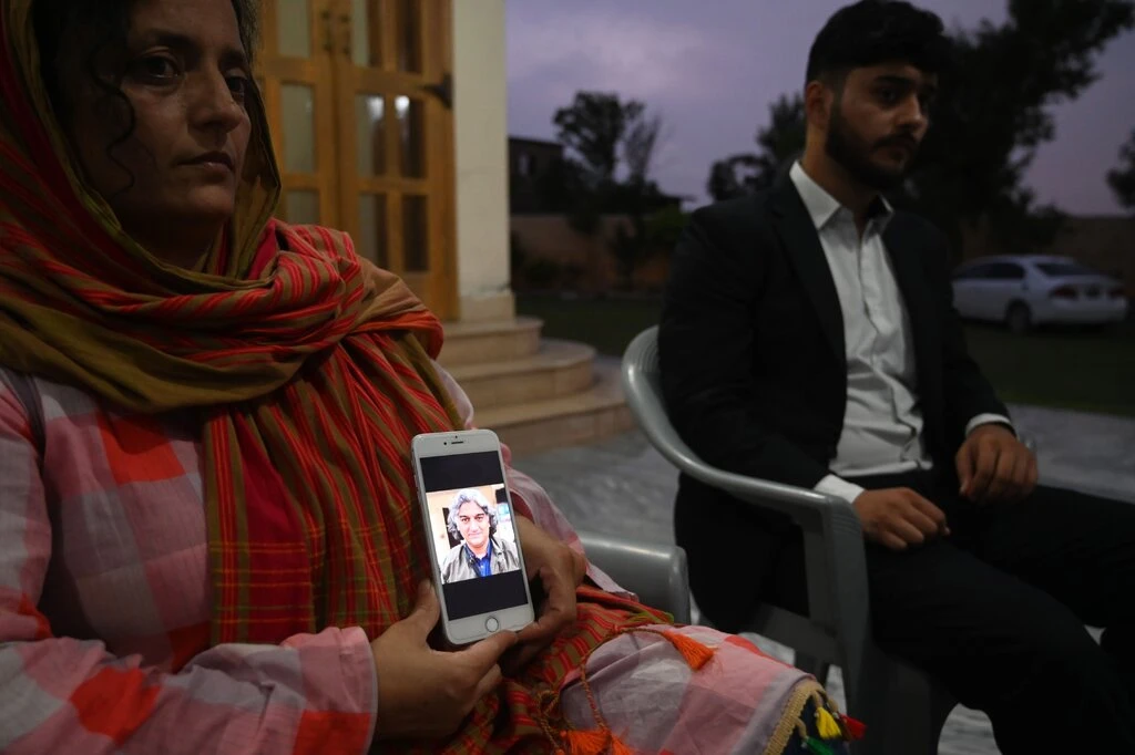 Kaneez Sughra, wife of the seized Pakistani journalist Matiullah Jan, shows a photograph of her husband. Mr. Jan was abducted from a street in Islamabad, Pakistan’s capital, in late July.Credit...Aamir Qureshi/Agence France-Presse — Getty Images