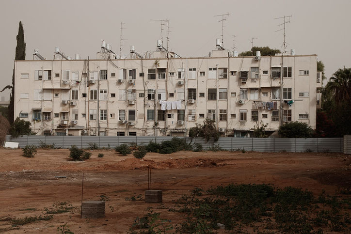 Old residential housing blocks and tall palm trees in a changing neighborhood in Tel Aviv, archive Flora Malinash.