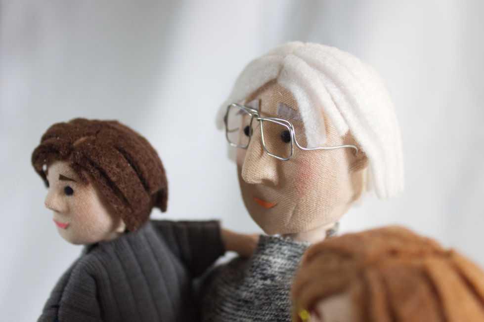 Close-up of textile and wooden puppets representing grandfather and grandchildren