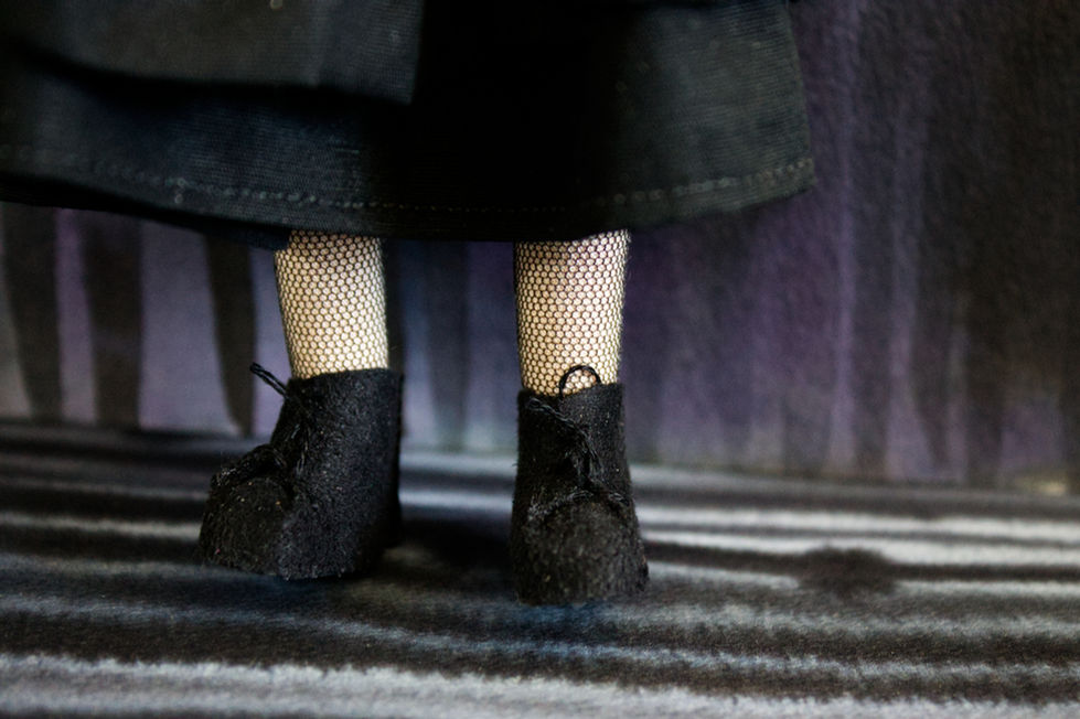 Close-up of Wednesday Addams puppet showing her boots