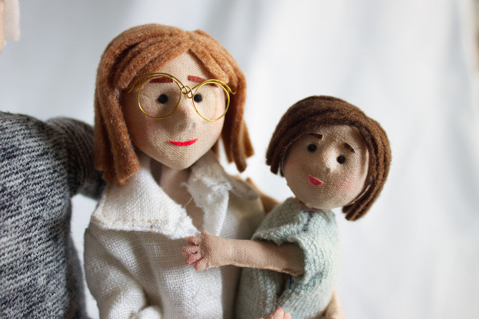 Close-up of textile and wooden puppets representing grandmother and grandchildren