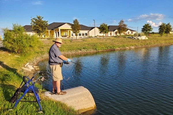 a man with a walker fishing at a lake