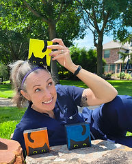 Artist Celeste Seitz with sample art on head