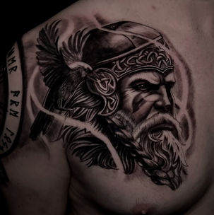 Detailed tattoo of a Viking warrior on a person's shoulder.