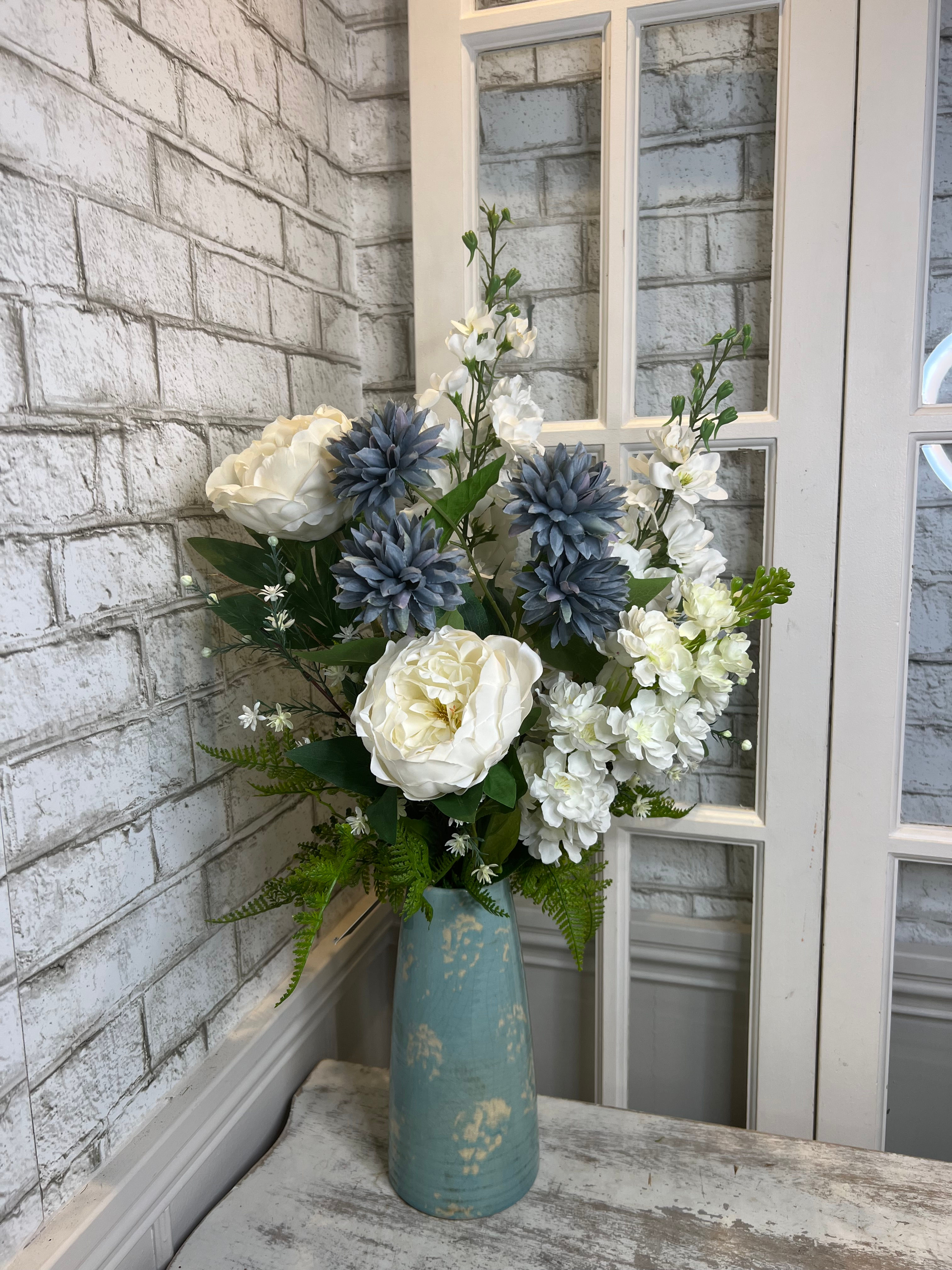 Montage bleu et blanc dans vase bleu.