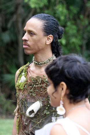 Male and female model wearing clothes and jewelry made from plants.