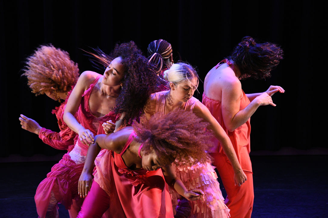 Female dancers wearing pink handmade costumes by Pangea Kali Virga on stage dancing.