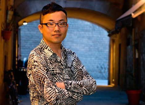 Portrait of Kentaro Nagai, co-founder of IMC, seated at a grand piano, capturing his deep connection to music and teaching.