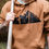 Thumbnail: close up of mountains hand stamped onto a hoodie worn by a rugged man holding an axe
