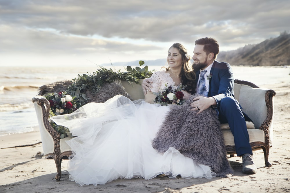 A married couple sitting on a sofa for their wedding photography