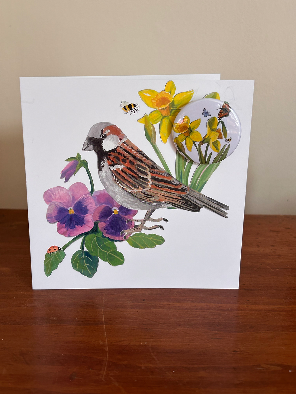 greetings card of house sparrow with daffodils, pansies and insects