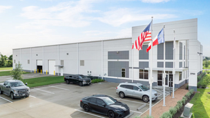 Newly built Class A industrial warehouse with dock-high doors, office frontage, and U.S. and Texas flags, address 3703