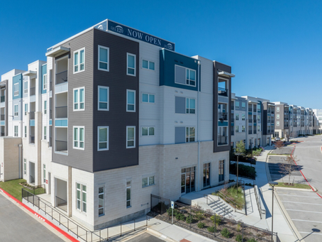 Newly completed multifamily apartment community with Now Open banner, illustrating market saturation analysis in feasibility studies