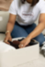 Professional organizer folding and arranging clothing in a storage bin