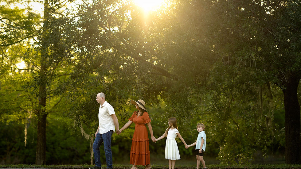 Beautiful family moment captured at sunset with dad, mom and their children near a lake in Central Florida