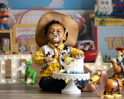 Baby dressed in a Toy Story-inspired cake smash session with themed props in Orlando.