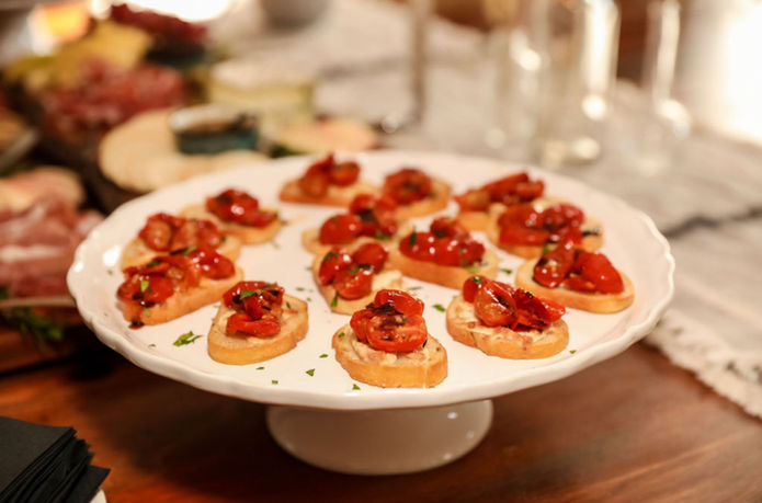 White platter holds crostini with roasted cherry tomatoes