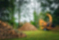 A tree chipper removing tree debris, leaving behind a neatly stacked pile of wood in Medina, Ohio.